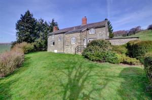 a large stone house on a grassy hill at 4 Bed in Presteigne oc-wak235 in Norton
