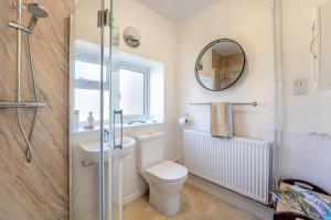 a bathroom with a toilet and a mirror at 4 Bed in Godalming oc-b30296 in Hook +23 photos