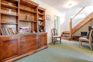 a living room with a wooden dresser and a staircase at 4 Bed in Godalming oc-b30296 in Hook