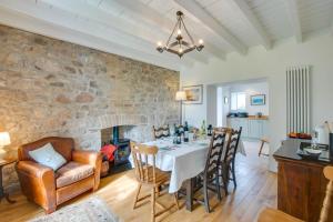 a dining room with a table and a stone wall at 5 Bed in Gower oc-hh101 in Port-Eynon