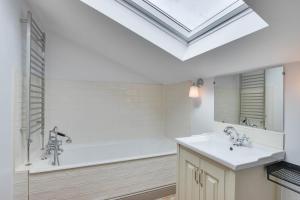 a bathroom with a sink and a bath tub with a skylight at 5 Bed in Gower oc-hh101 in Port-Eynon +21 photos