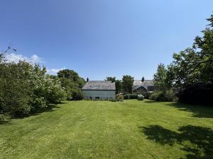 a large yard with a house in the background at 5 Bed in Gower oc-hh101 in Port-Eynon