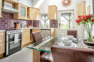 a kitchen with a glass table with chairs and a tableasteryasteryasteryasteryastery at 1 Bed in Mumbles oc-hh631 in Oystermouth