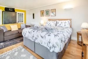 a bedroom with a large bed and a couch at 1 Bed in Mumbles oc-hh631 in Oystermouth
