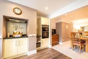 a kitchen and dining room with a clock on the wall at 4 Bed in Masham oc-ds1007 in Masham