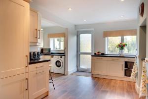 a kitchen with white cabinets and a washer and dryer at 4 Bed in Masham oc-ds1007 in Masham +15 photos