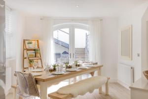 a white dining room with a table and chairs at 6 Bed in Pwllheli oc-argrai in Abersoch