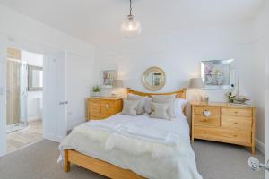 a bedroom with a large bed and a wooden dresser at 6 Bed in Pwllheli oc-argrai in Abersoch