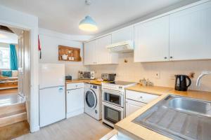 a kitchen with white cabinets and a sink at 2 Bed in Kendal oc-gl097 in Kendal +6 photos