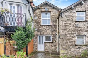 a stone house with a white door and a balcony at 2 Bed in Kendal oc-gl097 in Kendal