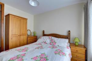 a bedroom with a bed with pink flowers on it at 2 Bed in Welshpool oc-wab256 in Berriew