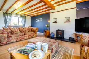 a living room with a couch and a fireplace at 3 Bed in Pwllheli oc-penmae in Pwllheli