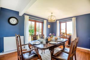a dining room with a table and chairs and a clock at 3 Bed in Pwllheli oc-penmae in Pwllheli