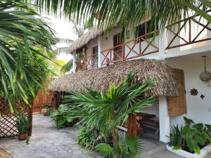 a building with a thatch roof and a courtyard at Casa OM in El Cuyo