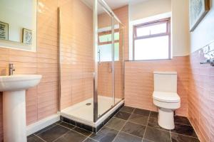 a bathroom with a shower and a toilet and a sink at 3 Bed in Pwllheli oc-penmae in Pwllheli +20 photos