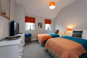 a bedroom with two beds and a flat screen tv at 4 Bed in Pwllheli oc-lluest in Abersoch