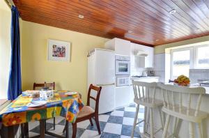 a kitchen with a table and a white refrigerator at 2 Bed in Caernarfon oc-wag359 in Caernarfon