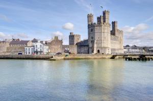 a castle sitting on top of a body of water at 2 Bed in Caernarfon oc-wag359 in Caernarfon +6 photos