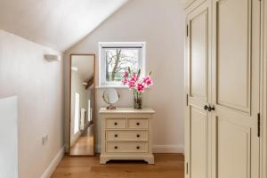 a vase of flowers on a dresser in a hallway at 1 Bed in Corwen oc-fl010 in Derwen