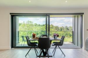a dining room with a table and chairs and a large window at 1 Bed in Buxted oc-t32799 in Buxted +13 photos