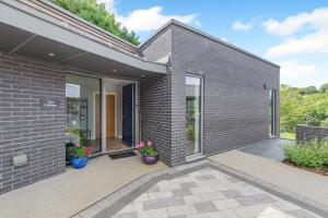 a brick house with two potted plants on a patio at 1 Bed in Buxted oc-t32799 in Buxted