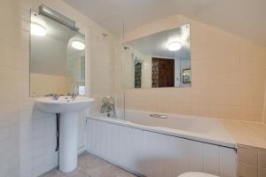 a bathroom with a sink and a tub and a mirror at 3 Bed in Binham oc-2235 in Binham +15 photos