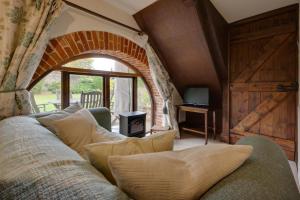 a living room with a couch and an archway at 3 Bed in Binham oc-2235 in Binham