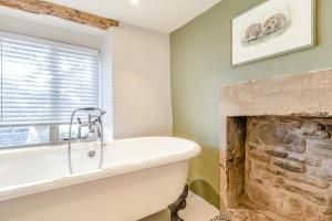 a bathroom with a bath tub and a fireplace at 3 Bed in Calver oc-h33087 in Curbar +20 photos