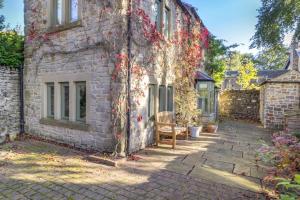 a brick building with a bench next to it at 3 Bed in Calver oc-h33087 in Curbar