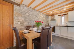 a kitchen and dining room with a wooden table and chairs at 3 Bed in Gower oc-hh407 in Llanmadoc +15 photos