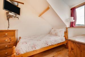 a bedroom with a bed and a tv on the wall at 3 Bed in Gower oc-hh407 in Llanmadoc