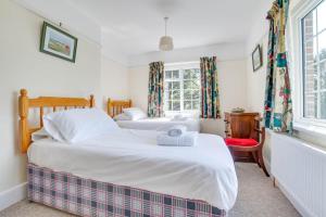two beds in a room with two windows at 4 Bed in Harmans Cross oc-wy278 in Corfe Castle