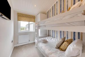 a bedroom with two bunk beds and a television at 3 Bed in Burnham Market oc-2334 in Burnham Market