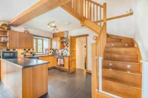 a kitchen with wooden cabinets and a staircase at 2 Bed in Bala oc-82768 in Llandderfel
