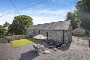a stone house with a table and an umbrella at 2 Bed in Bala oc-82768 in Llandderfel