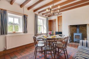 a dining room with a table and chairs and a fireplace at 3 Bed in Bakewell oc-dckno in Youlgreave