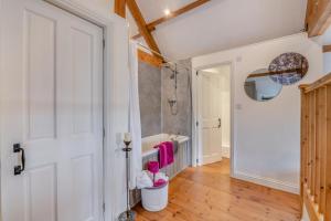 a bathroom with a tub and a sink and a door at 2 Bed in Glaisdale oc-wa306 in Glaisdale +16 photos