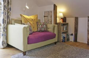 a living room with a couch with a purple cushion at 1 Bed in Woodbridge oc-tcl in Badingham