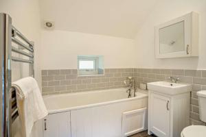 a bathroom with a tub and a sink and a toilet at 3 Bed in Defynnog oc-p33133 in Devynock +41 photos