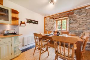 a kitchen with a table and chairs and a stone wall at 3 Bed in Dolgellau oc-wah569 in Llanfachreth