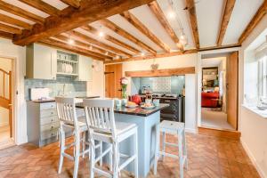 a kitchen with a blue island with bar stools at 2 Bed in Snape oc-wico in Snape