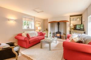 a living room with two red couches and a fire place at 2 Bed in Snape oc-wico in Snape
