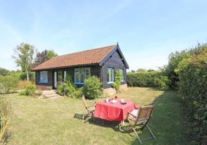 a small house with a table and chairs in a yard at 1 Bed in Beccles oc-mcn in Henstead