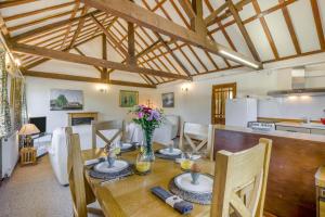 a kitchen and dining room with a table with flowers on it at 2 Bed in Smallburgh oc-h33733 in Dilham