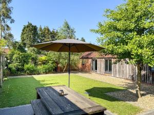 a picnic table with an umbrella in a yard at 3 Bed in Wood Dalling oc-caba in Wood Dalling