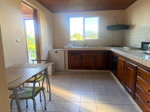 a kitchen with a sink and a table with chairs at Roger et Micheline a Kaz in Le Carbet