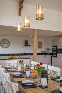 a long table with white chairs and a kitchen at 5 Bed in Briston oc-2305 in Briston