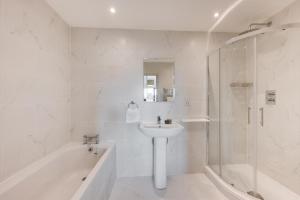 a white bathroom with a sink and a shower at 5 Bed in Briston oc-2305 in Briston +28 photos