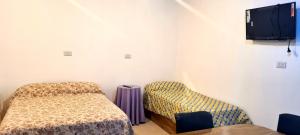 a room with a bed and a chair and a tv at Tres Hermanos in Trinidad