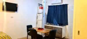 a small dining room with a table and a refrigerator at Tres Hermanos in Trinidad